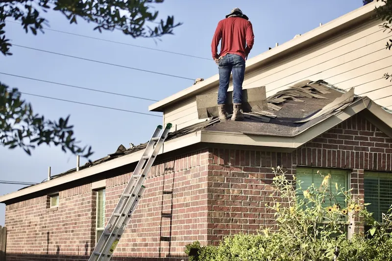 Professional roofer working on a residential roof in Greenway Park